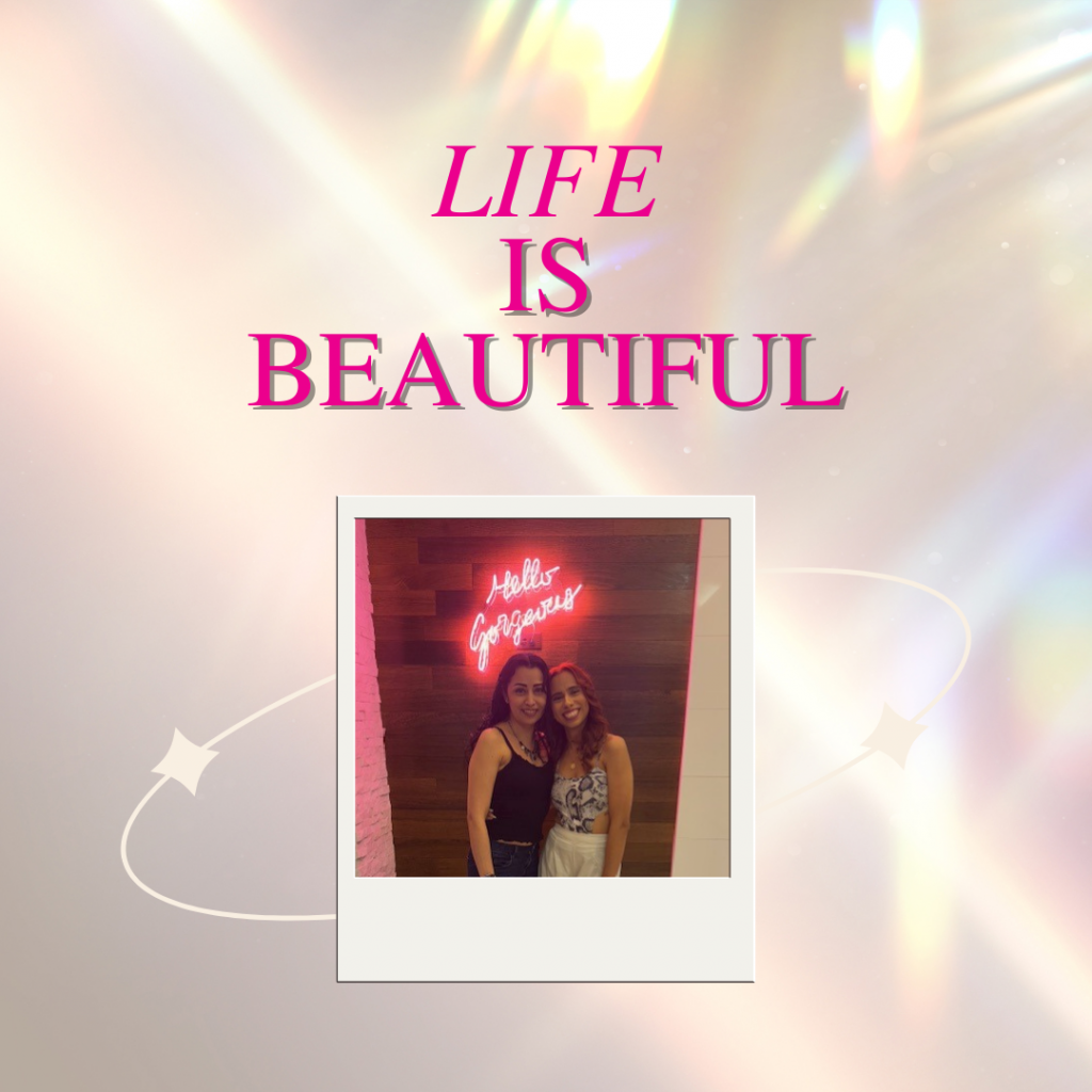 Woman standing in front of an illuminated sign that says ‘Hello Gorgeous